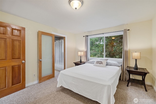 bedroom featuring baseboards and light colored carpet