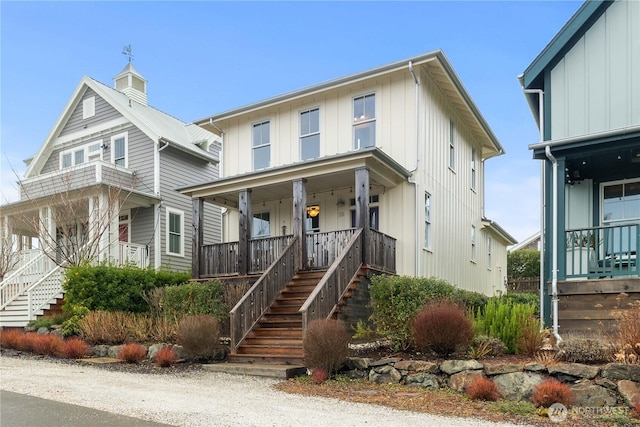 view of front of home featuring board and batten siding, stairs, and covered porch