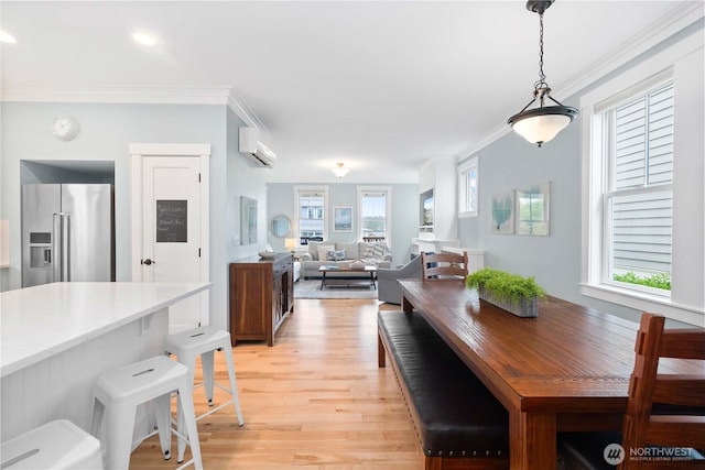 dining space featuring a wall mounted AC, light wood-style floors, and ornamental molding