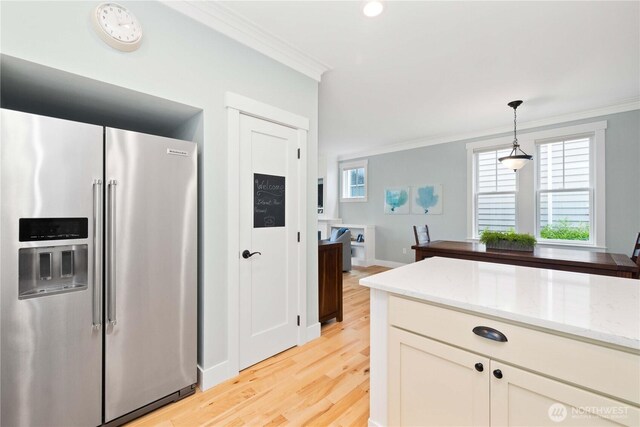 kitchen featuring light stone countertops, ornamental molding, light wood-style floors, pendant lighting, and high end refrigerator