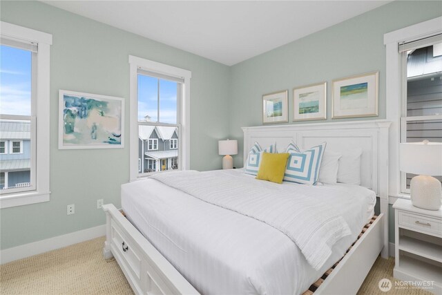 bedroom with baseboards and light carpet