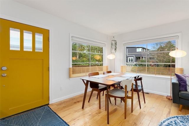 dining area with baseboards and light wood-style floors