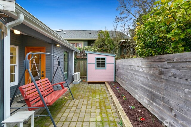 exterior space with a shed, central AC unit, an outdoor structure, and a fenced backyard