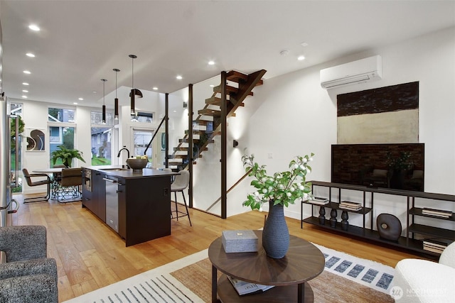 living room with recessed lighting, stairs, light wood-style floors, and a wall unit AC