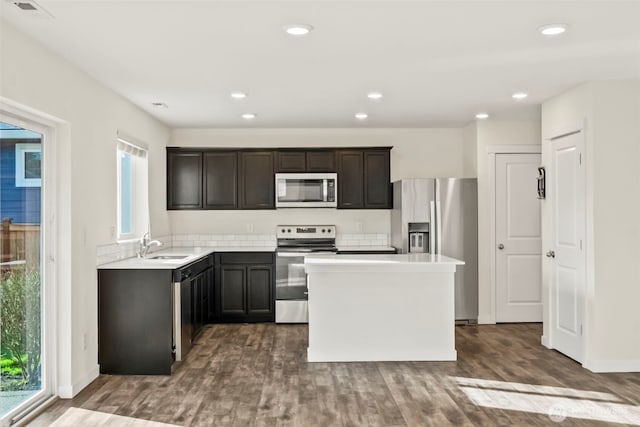 kitchen with recessed lighting, stainless steel appliances, dark wood-type flooring, and a kitchen island