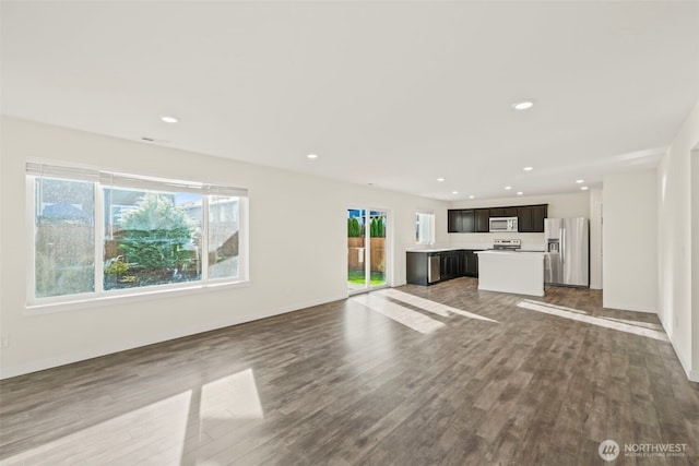 unfurnished living room with recessed lighting, baseboards, and wood finished floors