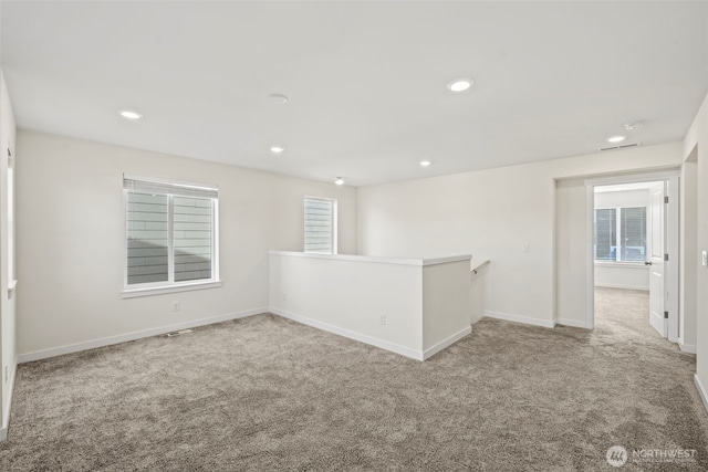 carpeted spare room with recessed lighting, baseboards, and plenty of natural light