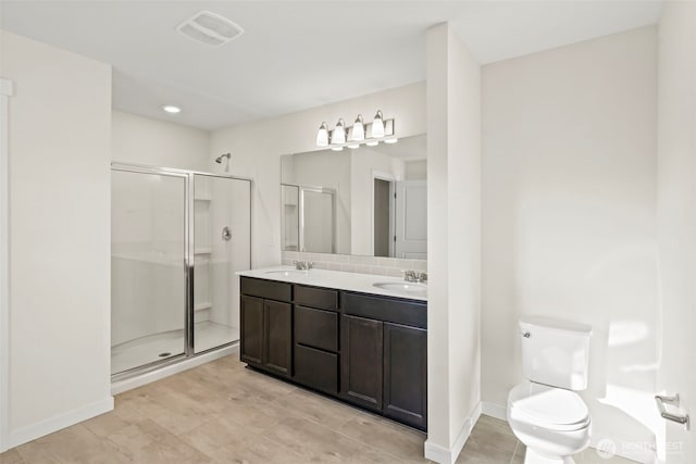 full bathroom with visible vents, toilet, a sink, a shower stall, and double vanity