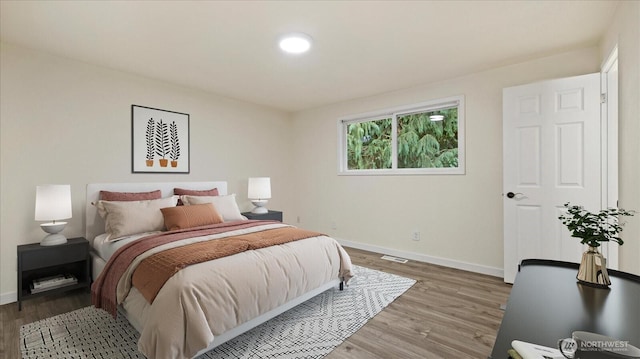 bedroom featuring visible vents, baseboards, and light wood-style floors