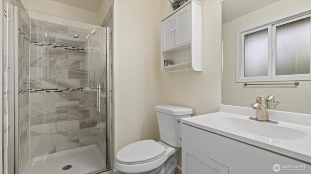 full bath featuring a stall shower, toilet, and vanity