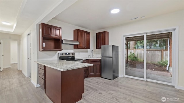 kitchen featuring visible vents, light wood finished floors, a sink, stainless steel appliances, and exhaust hood