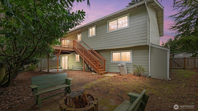 back of house featuring stairs, a deck, and a fenced backyard