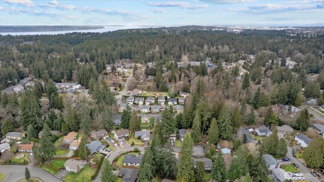 drone / aerial view featuring a residential view, a water view, and a wooded view