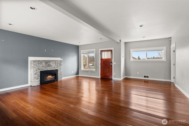 unfurnished living room with visible vents, baseboards, and wood finished floors