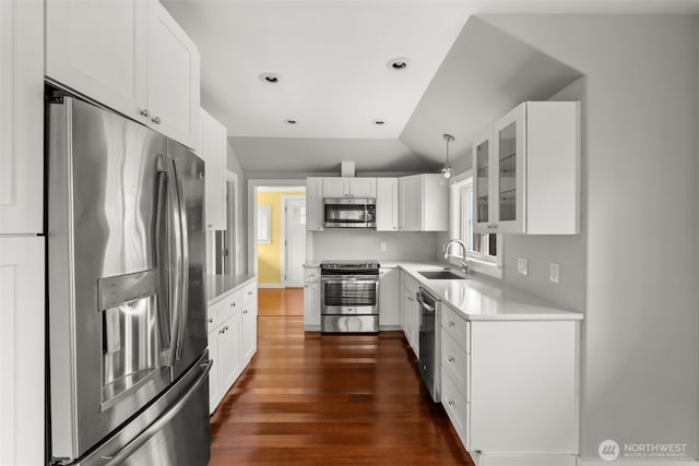 kitchen featuring a sink, dark wood finished floors, stainless steel appliances, light countertops, and lofted ceiling