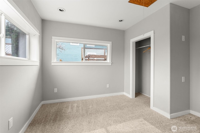 unfurnished bedroom featuring baseboards, carpet floors, and a closet