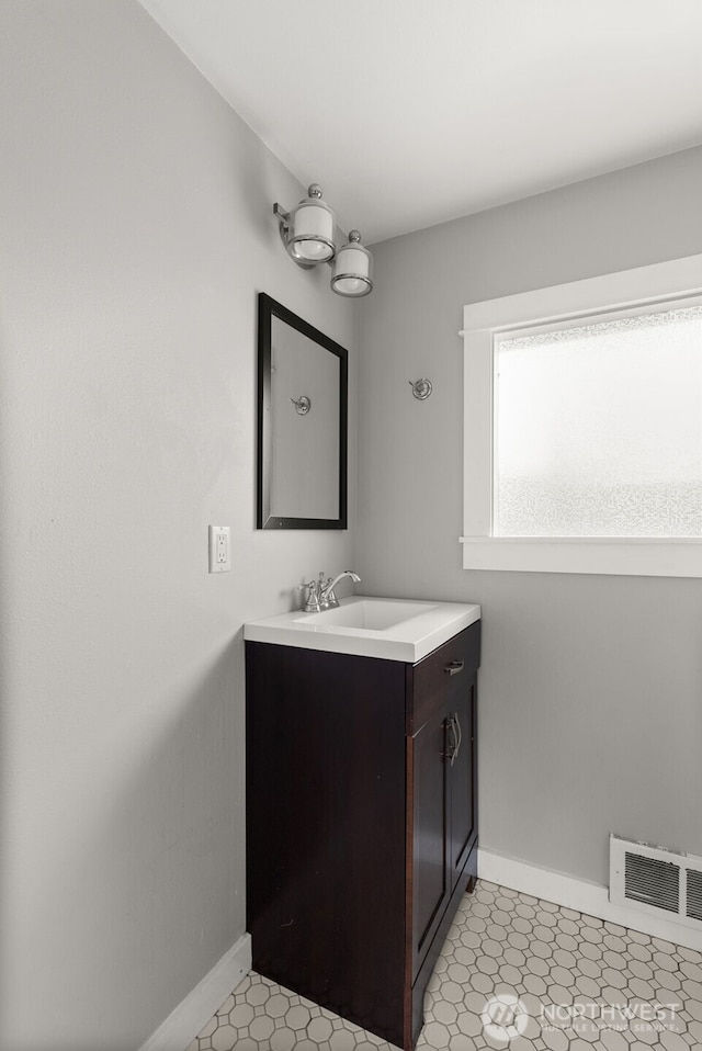 bathroom featuring visible vents, vanity, and baseboards