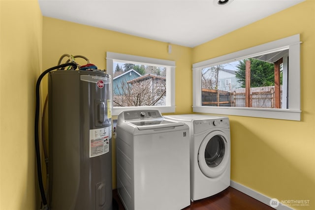 laundry room with water heater, laundry area, baseboards, dark wood-style flooring, and washing machine and clothes dryer