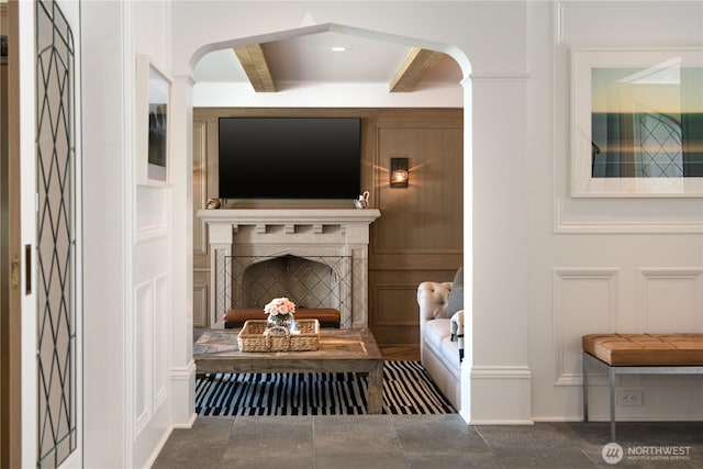 mudroom with beamed ceiling, a decorative wall, and a fireplace