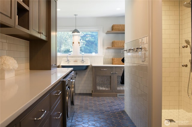 kitchen with open shelves, tile walls, light countertops, and a sink