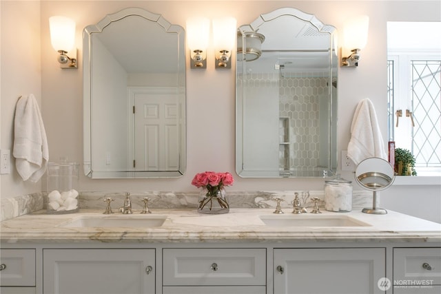 bathroom featuring double vanity, a wealth of natural light, and a sink