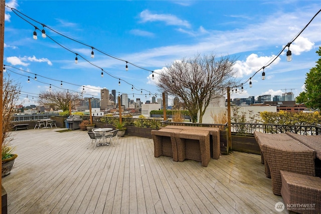 wooden deck featuring a city view and outdoor dining space