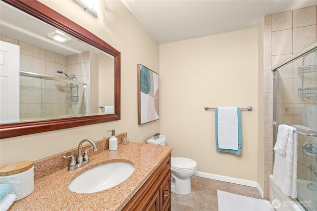 full bath featuring vanity, baseboards, a tile shower, tile patterned flooring, and toilet