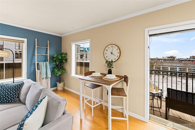 living area featuring baseboards, wood finished floors, and crown molding