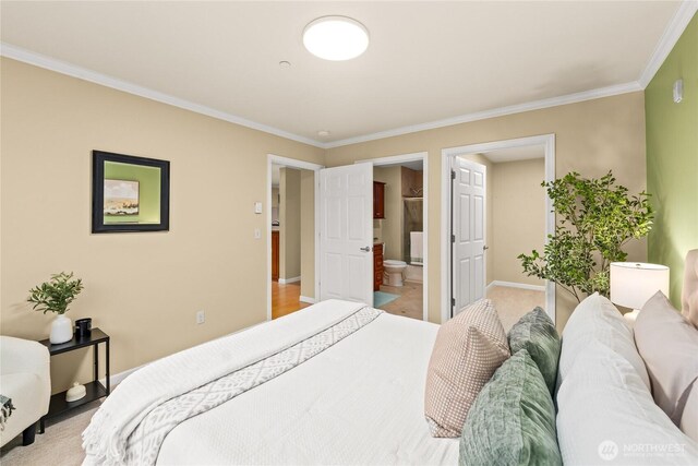 bedroom featuring ensuite bath, baseboards, and ornamental molding