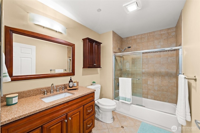 full bath with tile patterned flooring, toilet, vanity, and combined bath / shower with glass door