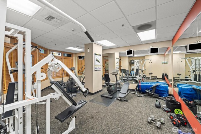 gym featuring a paneled ceiling and visible vents