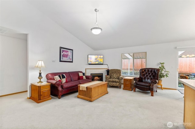 living area with baseboards, light colored carpet, and a fireplace