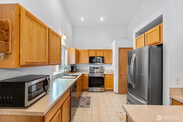 kitchen featuring light floors, light countertops, a high ceiling, stainless steel appliances, and a sink