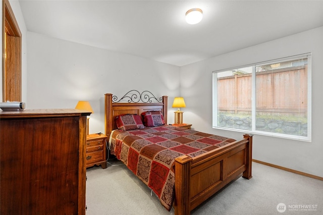 bedroom with baseboards and light colored carpet