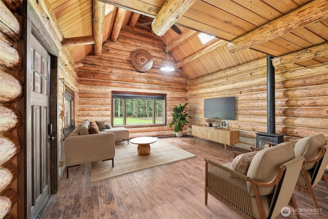 living room featuring hardwood / wood-style floors, a skylight, a wood stove, wooden ceiling, and beamed ceiling