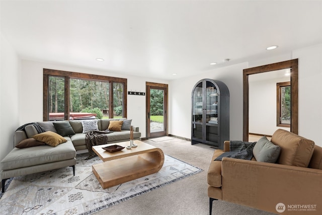 living area with recessed lighting, light colored carpet, and baseboards