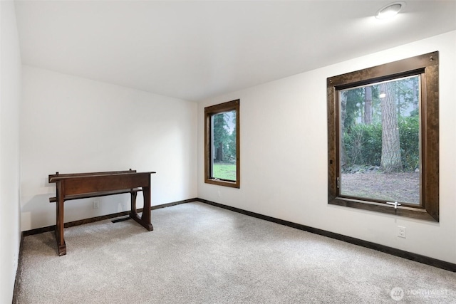 carpeted spare room featuring baseboards