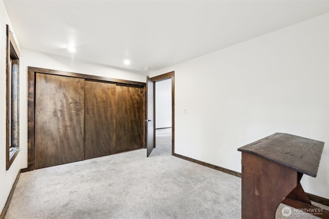 unfurnished bedroom with light colored carpet and baseboards