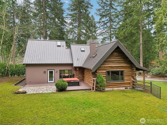 back of house featuring a standing seam roof, a yard, metal roof, log exterior, and a chimney