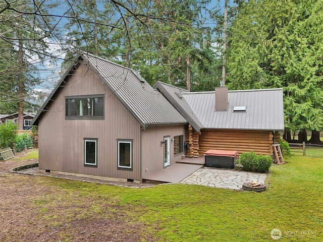 back of house featuring fence, crawl space, a patio area, a lawn, and metal roof