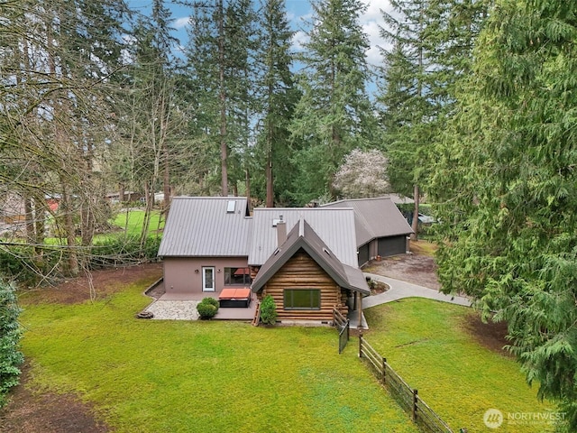 view of front of home with a front yard, fence, crawl space, log exterior, and metal roof