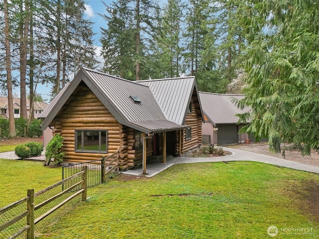 cabin with driveway, a front lawn, fence, a garage, and log exterior