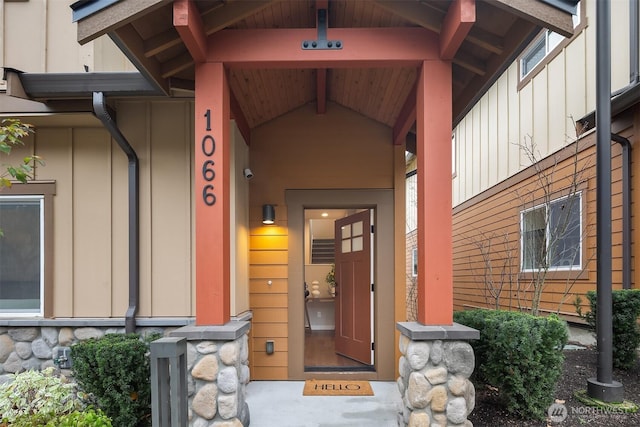 entrance to property featuring stone siding and board and batten siding