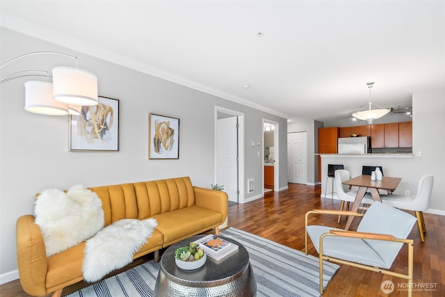 living area featuring wood finished floors, baseboards, and ornamental molding