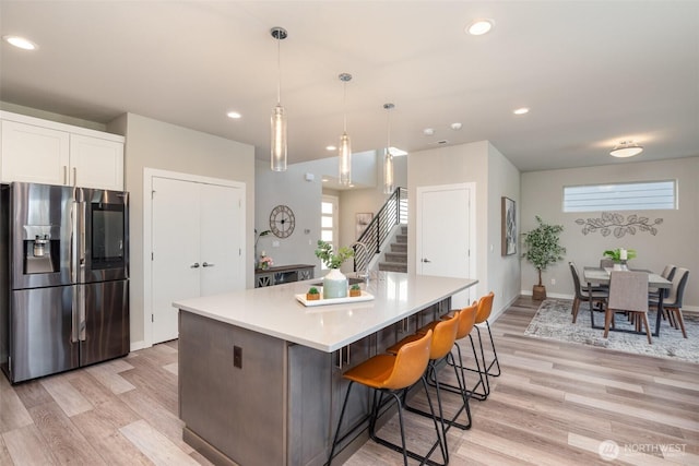 kitchen featuring white cabinets, recessed lighting, stainless steel refrigerator with ice dispenser, and light wood-type flooring