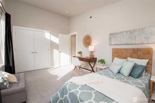 carpeted bedroom featuring a closet, visible vents, and a towering ceiling