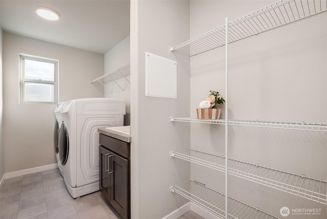 washroom featuring washer and clothes dryer, laundry area, and baseboards