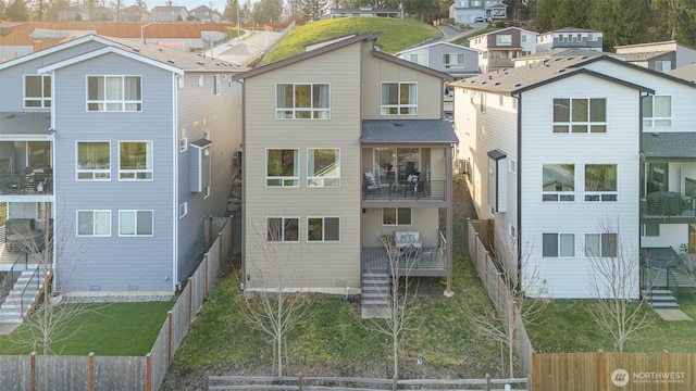 rear view of house featuring a residential view and fence