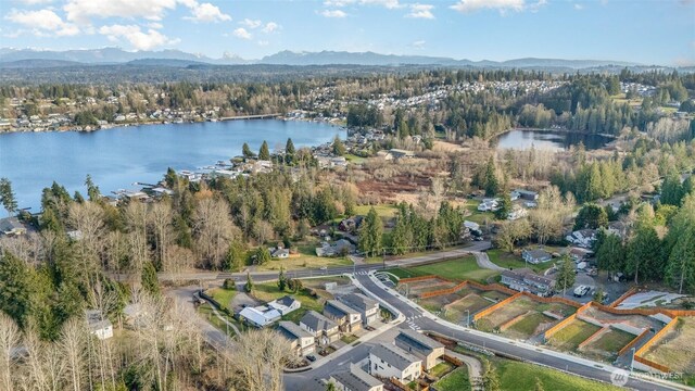 birds eye view of property with a view of trees and a water and mountain view