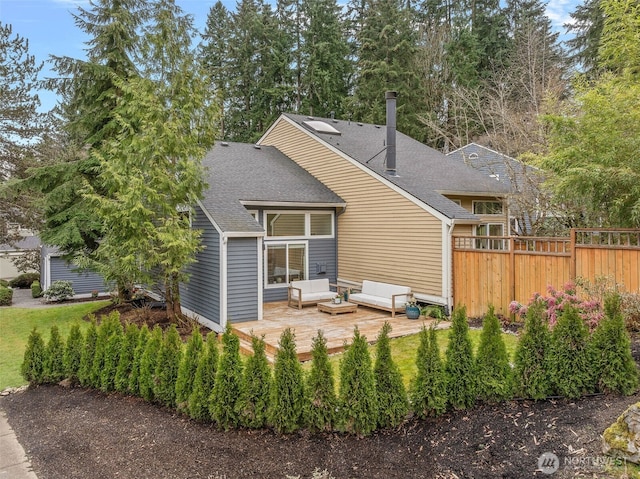 back of property featuring fence, roof with shingles, outdoor lounge area, a chimney, and a deck